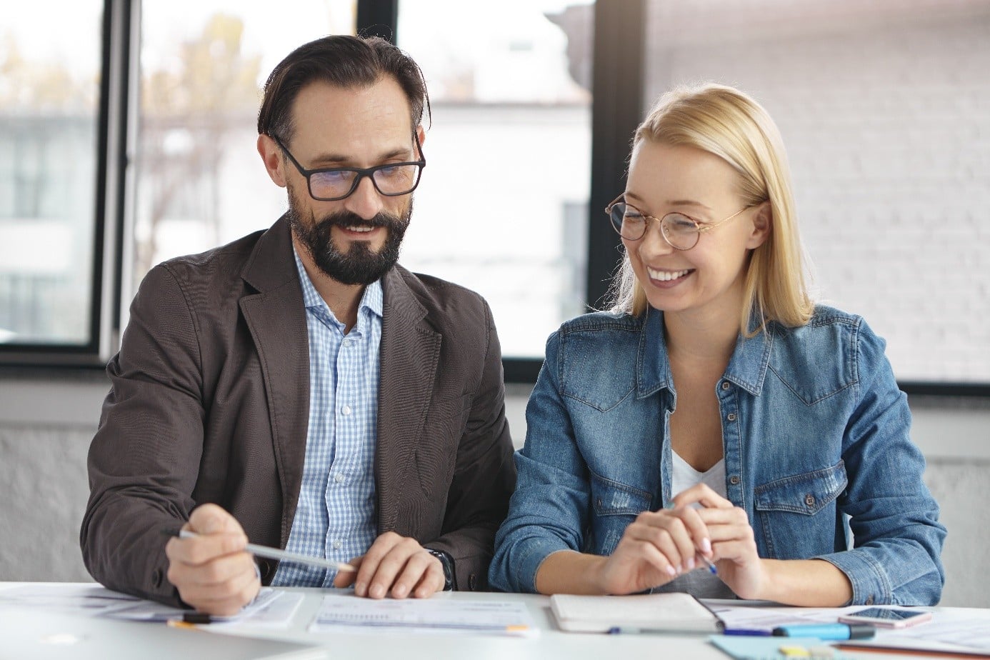 Choisir entre achat et location de défibrillateur : deux dirigeants d'entreprise étudient un devis.